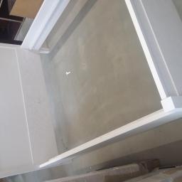 Zakład Stolarski Tadeusz Chodera - Biała rama meblowa w trakcie montażu, widoczne elementy konstrukcyjne i surowa podłoga w tle.