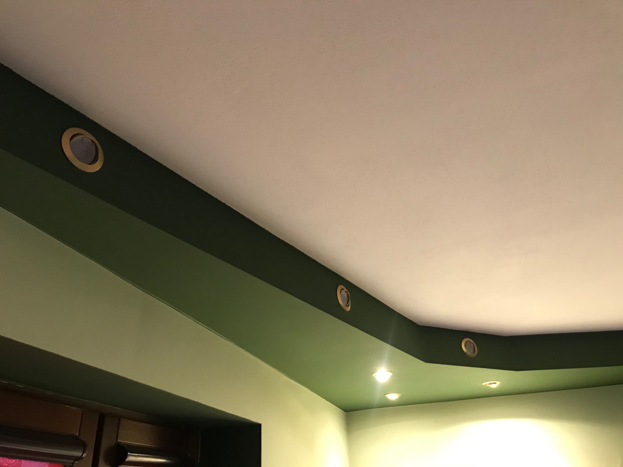 Sufit z oświetleniem punktowym LED w ozdobnej, zielonej obudowie, widok z dołu.