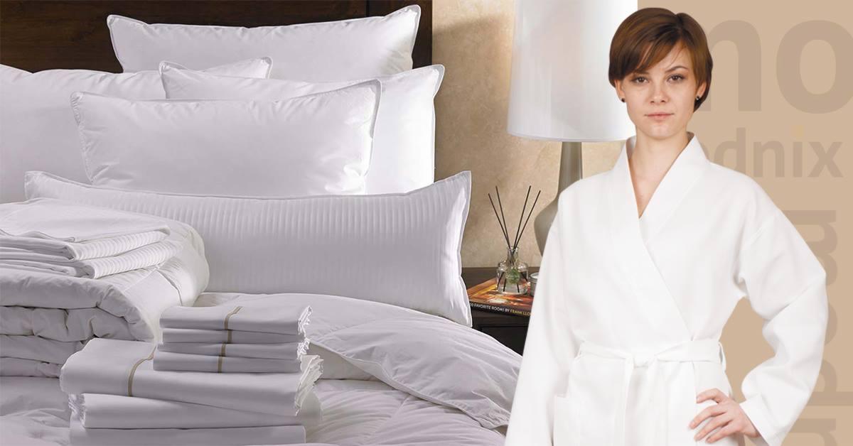 Prezentacja białej pościeli i ręczników na łóżku, obok kobieta w szlafroku, sugerująca ofertę szycia pościeli w Херсоне.
