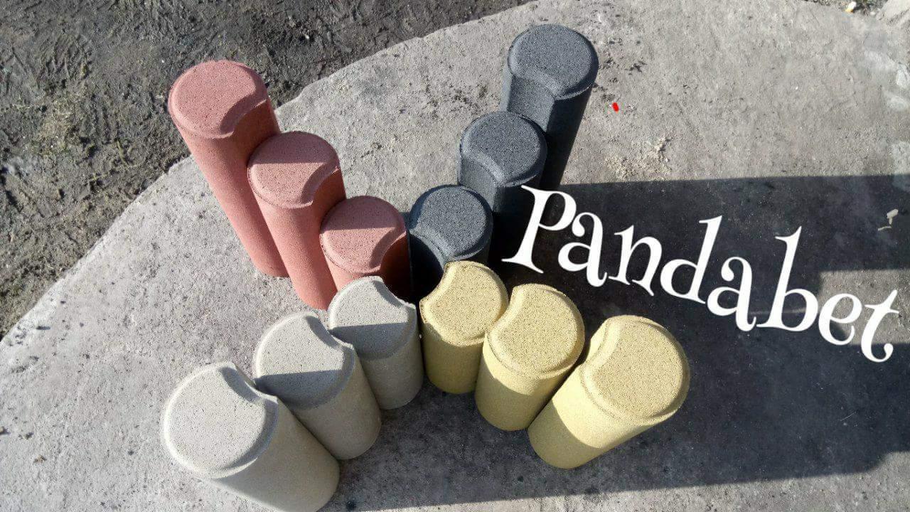 Różnokolorowe betonowe obrzeża trawnikowe PandaBet ułożone na betonowej nawierzchni, widoczne cienie i logo firmy.