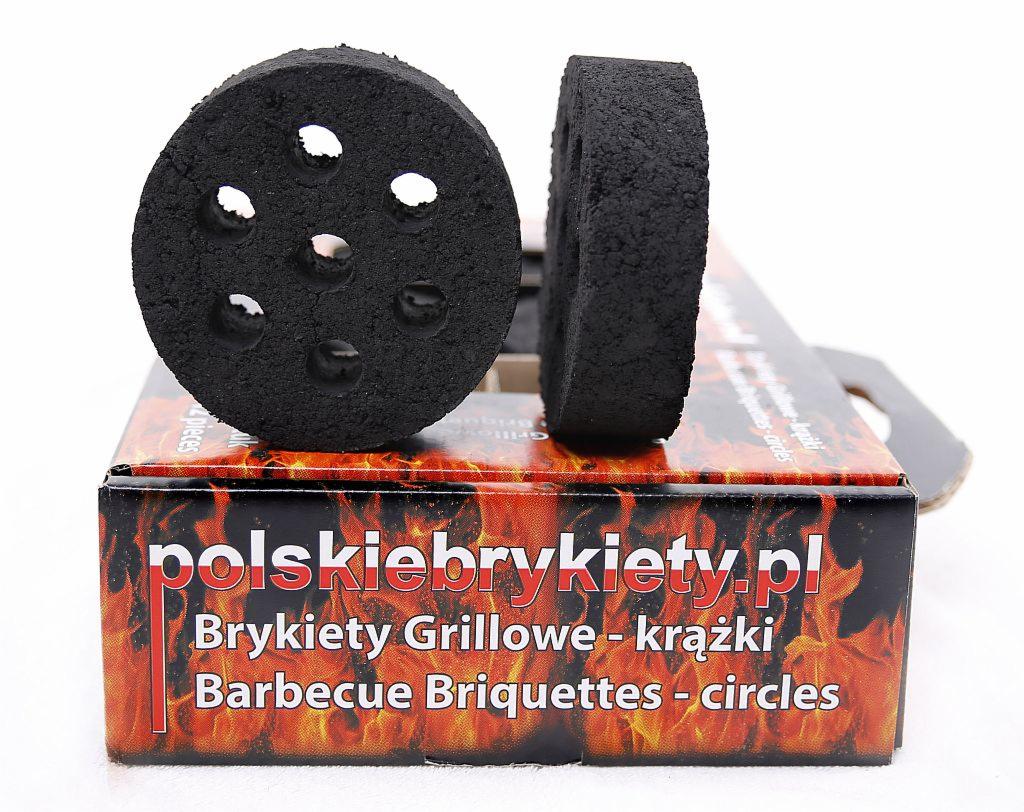 Dwa okrągłe brykiety grillowe z otworami, ustawione na kartonowym opakowaniu z płomieniami i napisem 'polskiebrykiety.pl'
