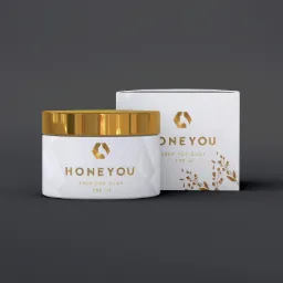 Elegancki słoiczek kremu pod oczy Honeyou z złotym wieczkiem i pasujące pudełko na ciemnoszarym tle, prezentacja produktu.