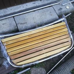 F.U.H Invest-Kop - Element konstrukcyjny z drewnianych listew i chromowanej ramy, owinięty folią, leżący na ziemi obok betonowych płyt i rur.