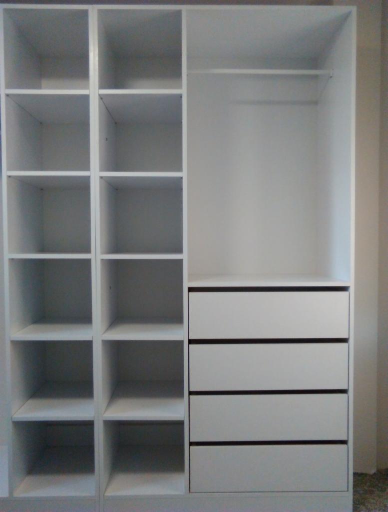 Wnętrze białej szafy z półkami i czterema szufladami, widok z przodu na pustą konstrukcję przed zagospodarowaniem.