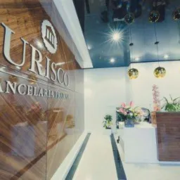 Eleganckie wnętrze kancelarii prawnej z drewnianą ścianą z logo, recepcją z kwiatami i designerskimi lampami wiszącymi.