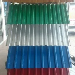 Ekspozycja profili dachowych w różnych kolorach: brązowym, zielonym, srebrnym, niebieskim i czerwonym, z widocznym logo producenta na górze.