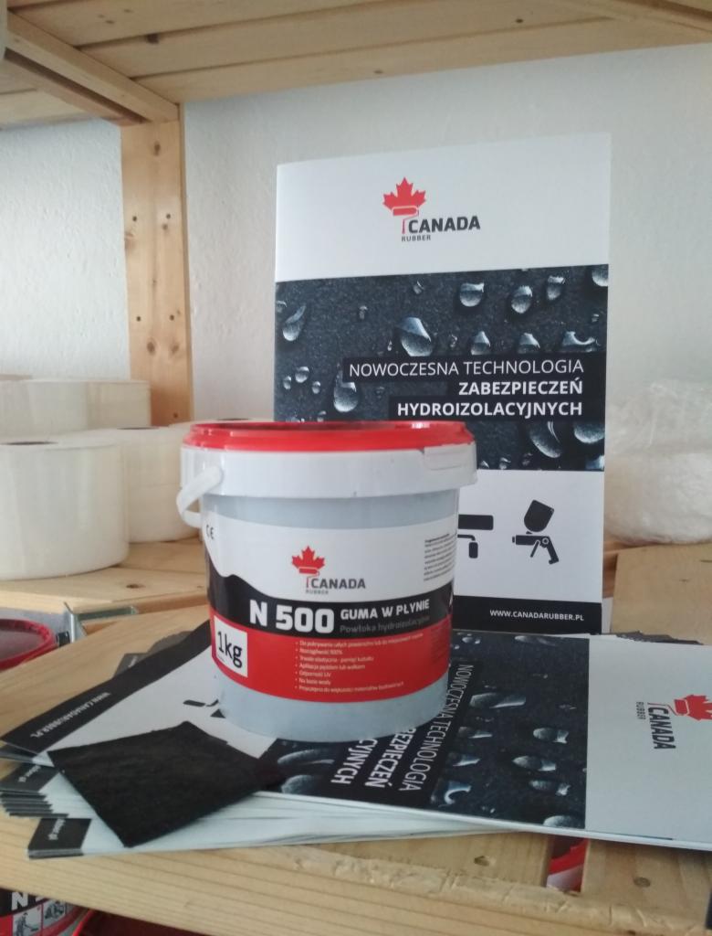 Pojemnik 1kg z gumą w płynie N500 marki Canada Rubber, prezentowany z materiałami reklamowymi, w tym ulotką z informacją o nowoczesnej technologii zabezpieczeń hydroizolacyjnych.