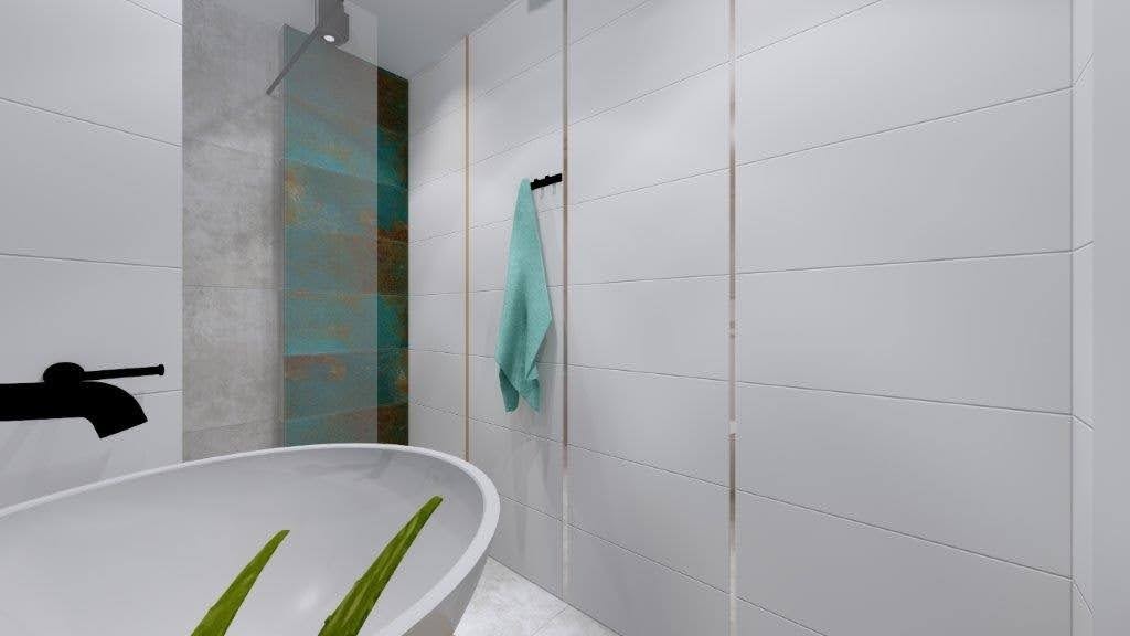 Nowoczesna łazienka z wolnostojącą wanną, czarną armaturą i białymi płytkami z delikatnymi złotymi akcentami, uzupełniona turkusowym ręcznikiem.