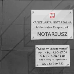 Tabliczka informacyjna na ścianie z ciemnych płytek, wskazująca na Kancelarię Notarialną Aleksandry Respondek, z godłem Polski i godzinami urzędowania.