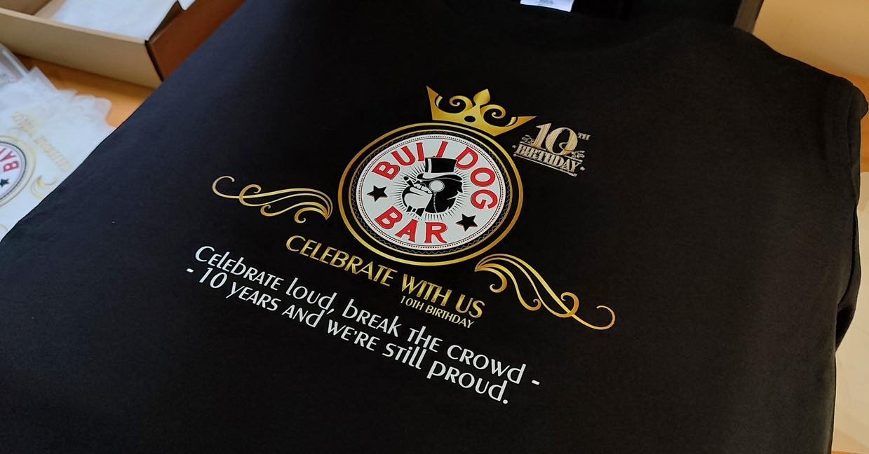 Czarna koszulka z okolicznościowym, złotym nadrukiem 'Bulldog Bar 10th Birthday' wykonanym w Bielsko-Białej.