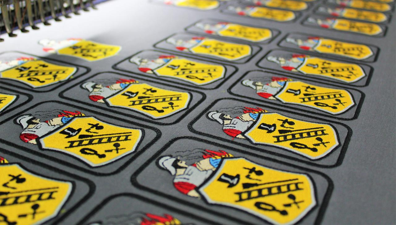 Arkusz z naszywkami z herbem strażackim, wykonanymi w Bielsku-Białej, gotowymi do wycięcia i naszycia na odzież.