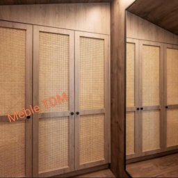 TDM - Wnętrze garderoby z szafami na wymiar, fronty z rattanową plecionką, drewniane wykończenie, widok z lustrzanego odbicia.