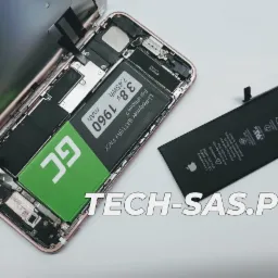 Otwarty iPhone 7 z widoczną baterią GC i odłączoną oryginalną baterią Li-ion, leżący na białym tle z adresem strony internetowej w dolnej części zdjęcia.