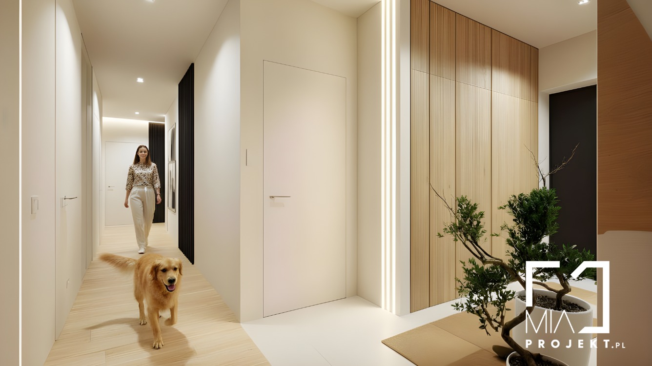 Nowoczesny korytarz z drewnianą ścianą, oświetleniem LED, minimalistycznymi drzwiami i psem rasy golden retriever, który biegnie w stronę kamery. W tle kobieta.