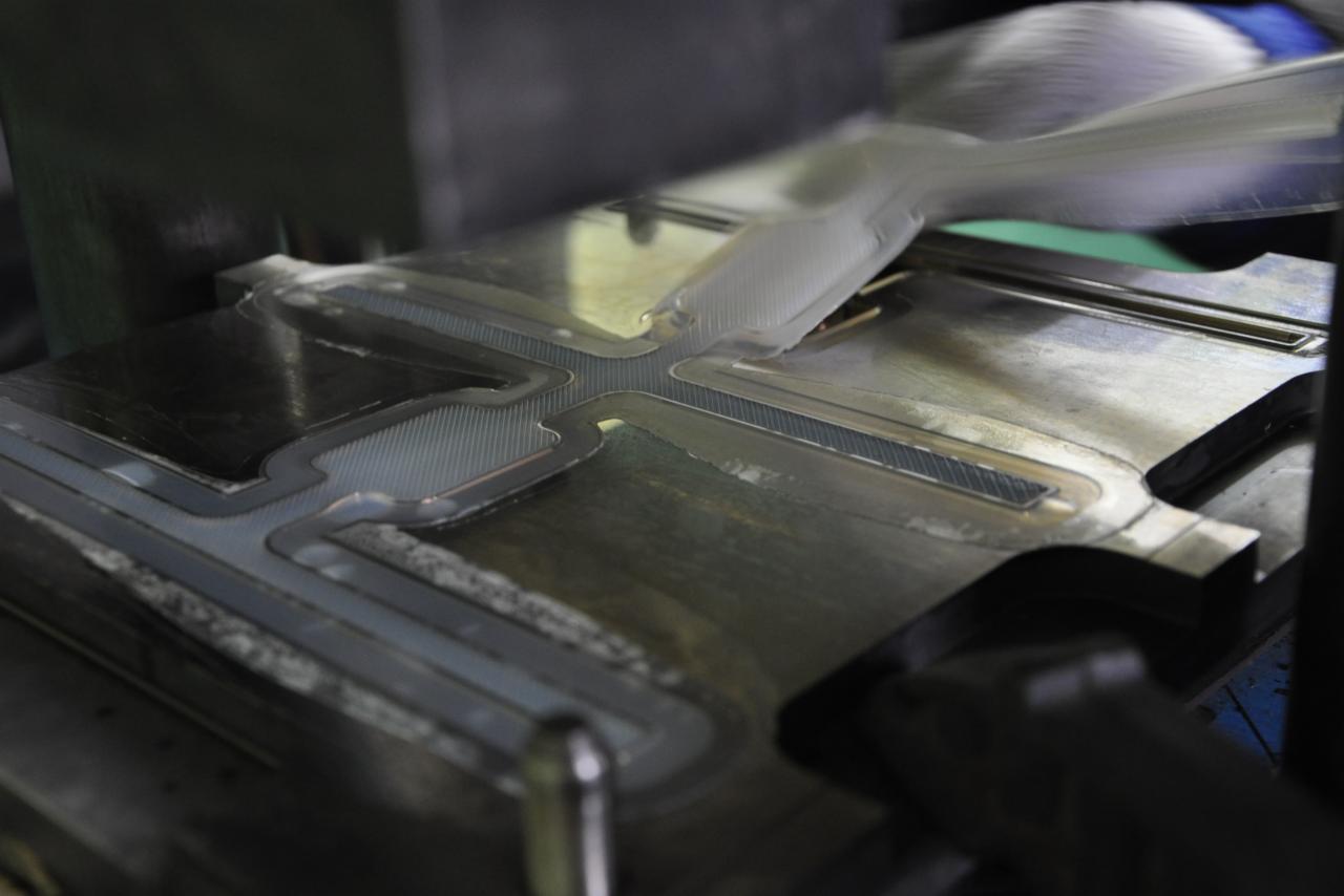 Forma do wtrysku z kanałami chłodzącymi, widoczne ślady obróbki i pozostałości materiału.