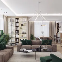 Przestronny salon z brązowymi sofami zdobionymi zielonymi poduszkami, dwie okrągłe kawowe ławy, regał z przeszklonymi drzwiami, jadalnia w tle, ściana z mchu i logo firmy w prawym dolnym rogu.