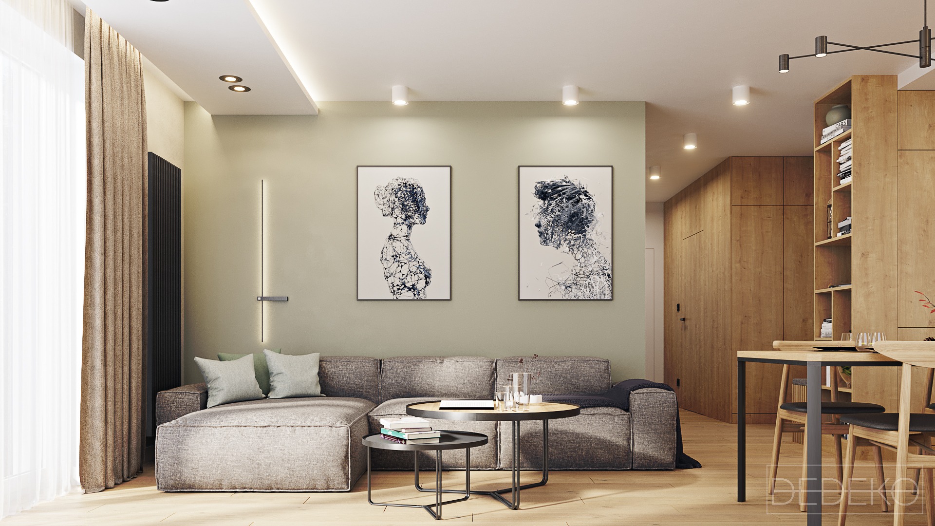 Nowoczesny salon z szarą sofą modułową, dwoma stolikami kawowymi, drewnianą zabudową kuchenną z otwartymi półkami i dwoma abstrakcyjnymi portretami na ścianie w kolorze oliwki.