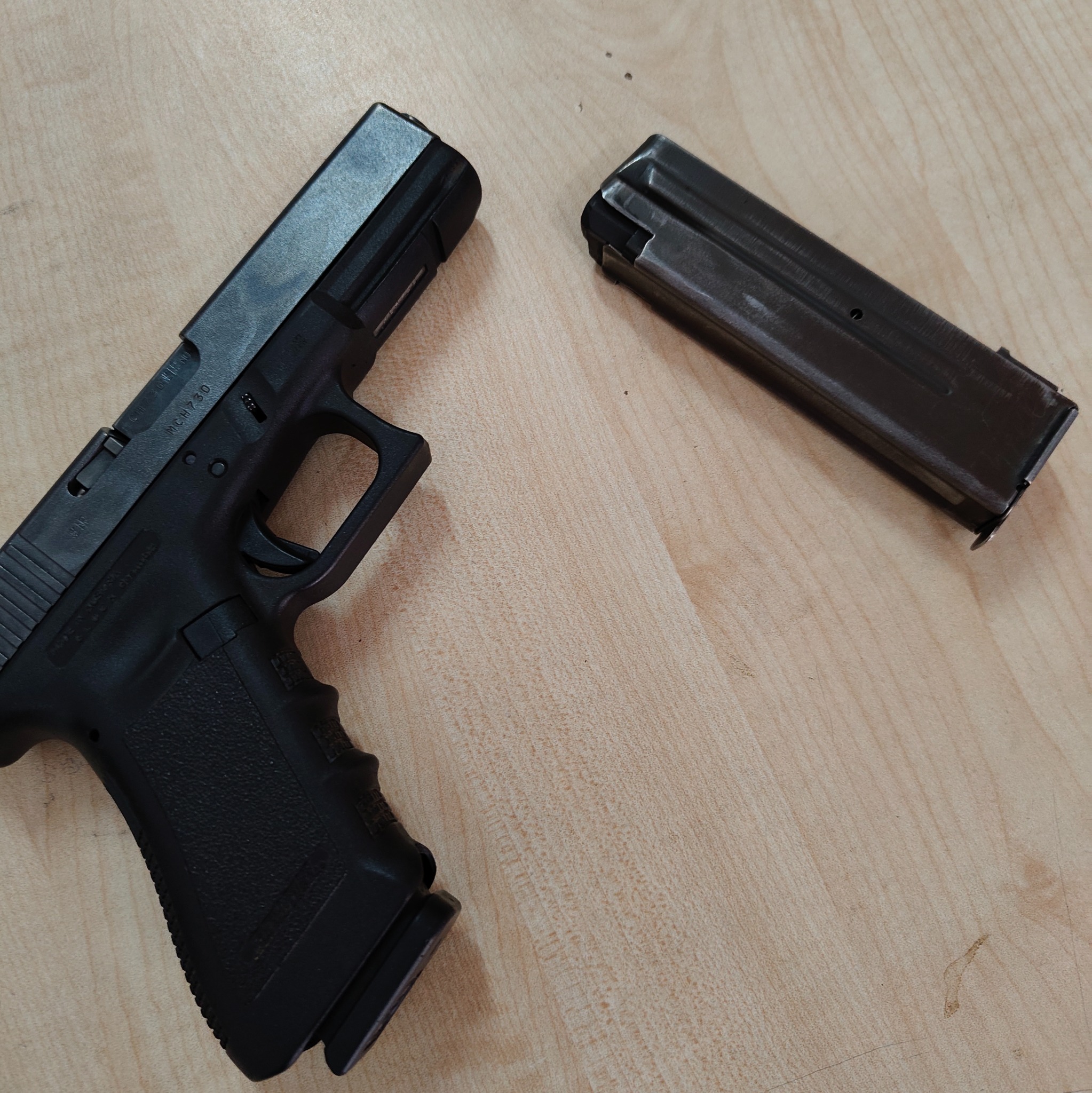 Czarny pistolet Glock i magazynek na jasnym tle, Skierniewice. Sprzęt używany podczas szkoleń strzeleckich lub przez pracowników ochrony.