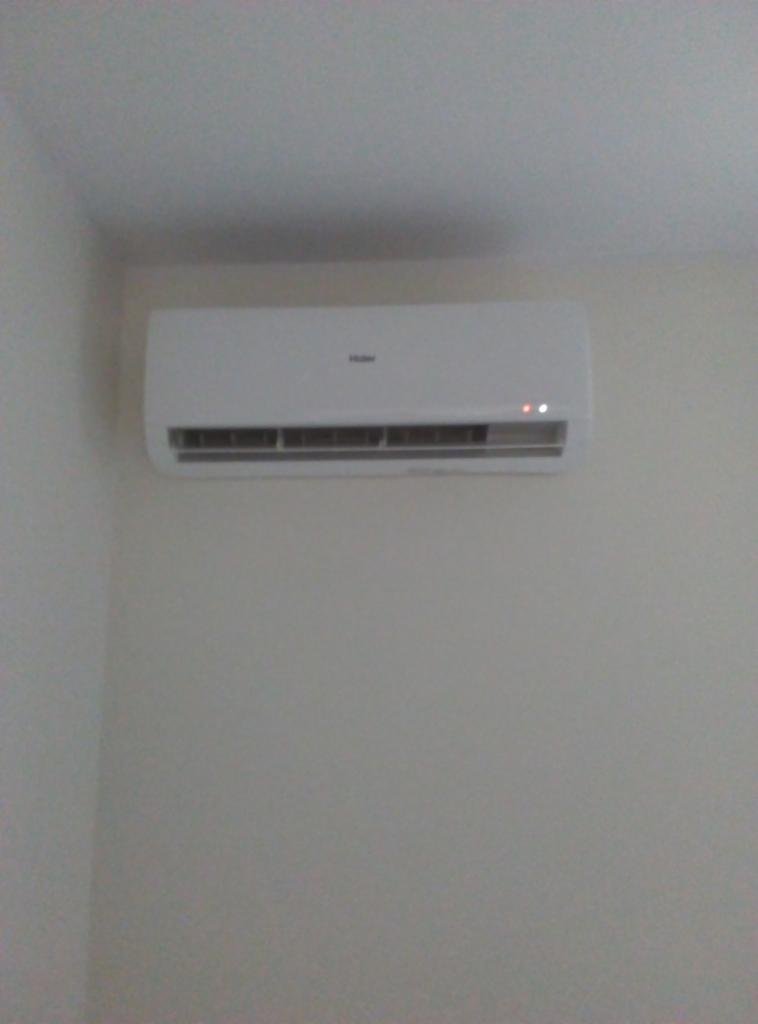 Biała jednostka klimatyzacyjna Haier zamontowana na ścianie w Chorzelach, z widocznymi diodami sygnalizacyjnymi.