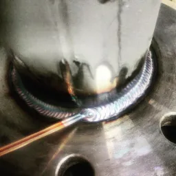 Metalowy rurociąg spawany metodą TIG, widoczne ślady ciepła i charakterystyczna struktura spoiny.