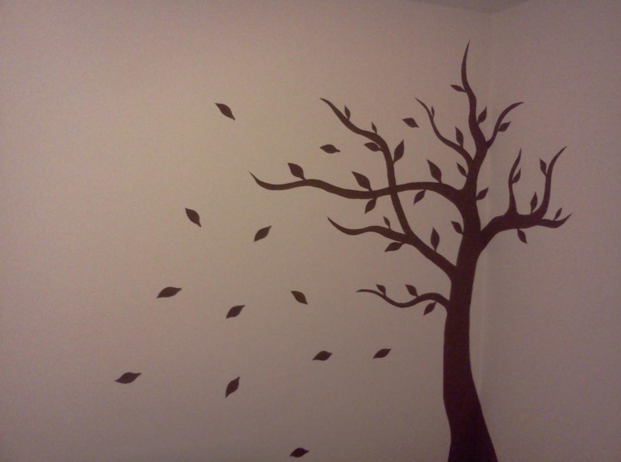 Dekoracja ścienna: brązowy motyw drzewa z opadającymi liśćmi na jasnej ścianie w pokoju. Subtelny akcent dekoracyjny.