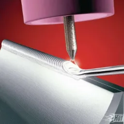 Precyzyjne łączenie metali metodą TIG, widoczna spoina o regularnej strukturze na krawędzi elementu, intensywne światło łuku elektrycznego.