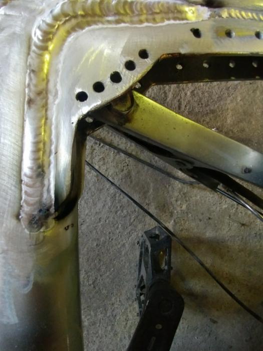 Detale spoin na metalowej ramie roweru, widoczne ślady obróbki i otwory montażowe.