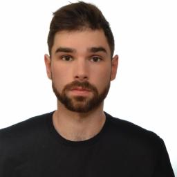 DNV Realiz LTD Sp. Z o.o. S.k - Portret młodego mężczyzny z brodą, w czarnej koszulce z logo Karla Lagerfelda na białym tle. Ujęcie od przodu, skupione na twarzy i górnej części torsu.