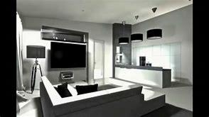 Monochromatyczne wnętrze nowoczesnego salonu z minimalistycznym narożnikiem, dużym telewizorem na ścianie i otwartą przestrzenią kuchenną z białym blatem. Widoczne czarne lampy wiszące i elementy...