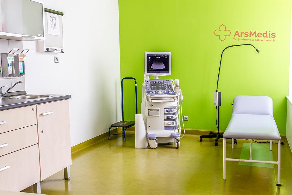 Gabinet lekarski z aparatem USG, leżanką i umywalką, ściana w kolorze limonki z logo ArsMedis.