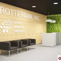 Wnętrze biura w Bielsko-Białej z drewnianą ścianą z logo i nazwą 'Rotterdam Inc.', napisem 'Kielecki Inkubator Logistyczny', białym biurkiem recepcyjnym i zieloną ścianą z mchu.