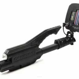 Czarny nieliniowy detektor złącz 'Cayman' na białym tle, widoczny wyświetlacz z poziomami sygnału i przyciskami sterującymi.