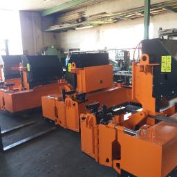 Turmet - Pomarańczowe, metalowe konstrukcje 'PolPlaner 01' ustawione rzędem w hali produkcyjnej w Szczecinku, widoczne wózki widłowe i inne maszyny w tle.