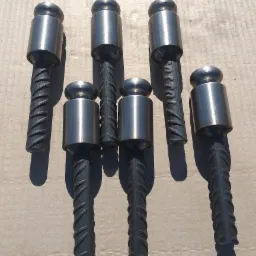 Sześć stalowych stempli z prętami żebrowanymi, ułożonych na szarym tle, widoczne cienie.