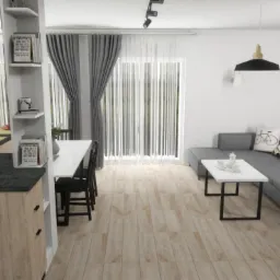 Wnętrze otwartej przestrzeni z kuchnią, jadalnią i salonem w neutralnych kolorach, z akcentem ceglanej ściany i owocami na blacie kuchennym.