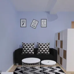Pokój z niebieskimi ścianami, czarną sofą z geometrycznymi poduszkami, dwoma białymi stolikami-koszykami i dywanem w czarno-białe zygzaki. Na ścianie wiszą trzy plakaty w czarnych ramkach.