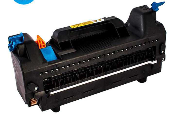 Czarny toner do drukarki z niebieskimi i pomarańczowymi elementami, widoczny pod kątem, na białym tle. Toner gotowy do montażu lub po regeneracji.