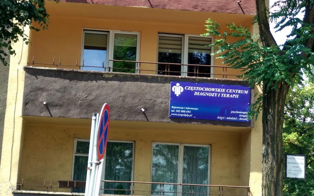 Fasada budynku Częstochowskiego Centrum Diagnozy i Terapii z niebieską tablicą informacyjną, widok z zewnątrz w słoneczny dzień.