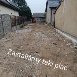 Teren przygotowany pod budowę, z widoczną mini koparką w oddali, otoczony zabudową jednorodzinną i ogrodzeniem.