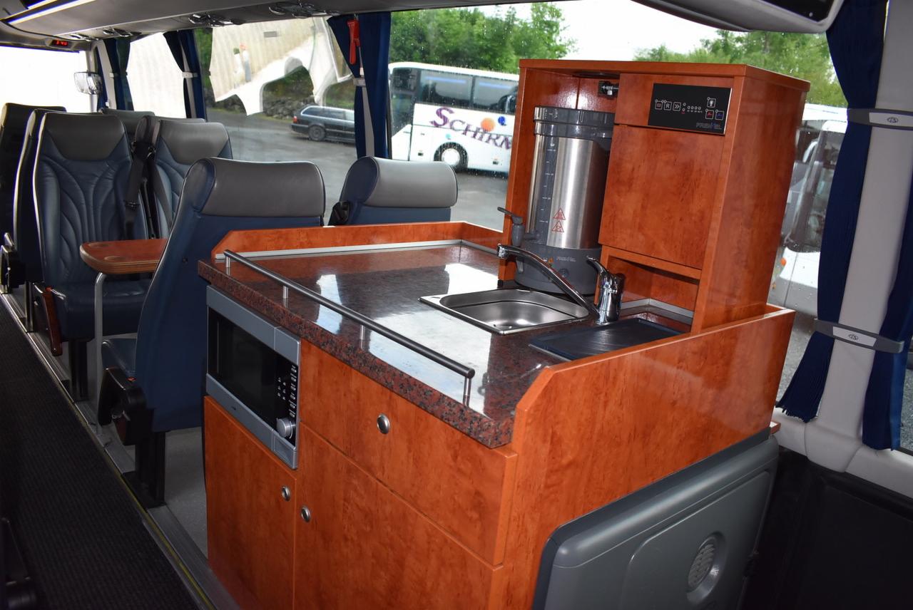 Wnętrze autobusu turystycznego z aneksem kuchennym: ekspres do kawy, zlew, mikrofalówka i marmurowy blat