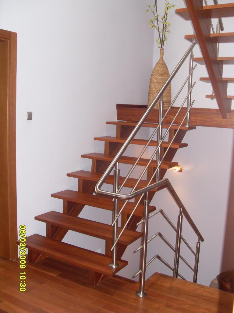 Drewniane schody z metalową balustradą w nowoczesnym wnętrzu, z widoczną datą na zdjęciu w lewym dolnym rogu, wskazującą na rok wykonania.