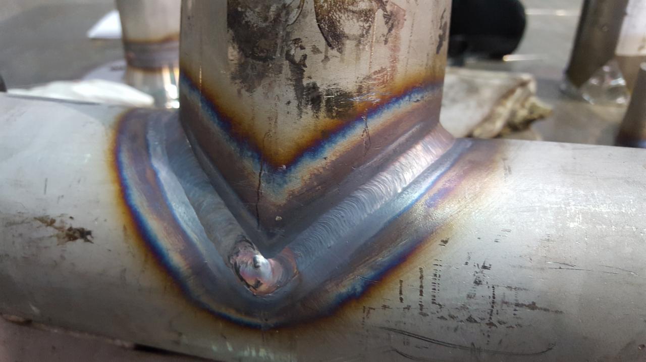 Spoina rurociągu ze stali nierdzewnej z widocznymi kolorami dyfrakcyjnymi, wskazującymi na temperaturę podczas spawania.