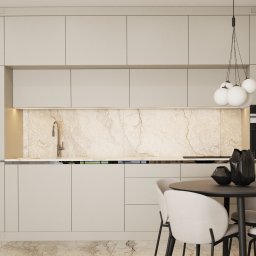 de AR - Beżowa kuchnia z marmurowym backsplashiem, okrągłym stołem i designerską lampą wiszącą z białymi kulami