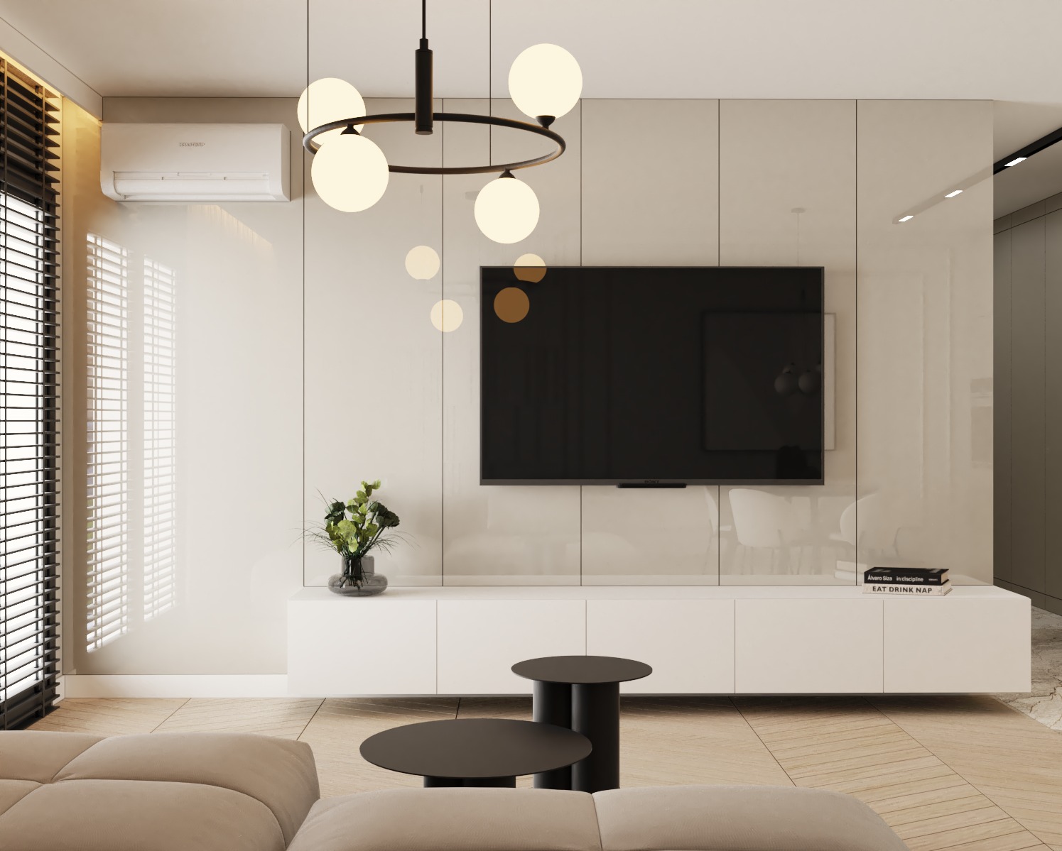 Nowoczesny salon z beżową sofą modułową, białą szafką RTV, czarnym telewizorem, okrągłym żyrandolem z kulistymi kloszami i drewnianą podłogą ułożoną w jodełkę.