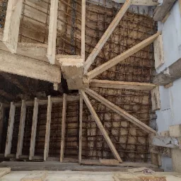 Konstrukcja szalunkowa i zbrojenie spiralnych schodów betonowych w trakcie budowy, widok z góry.