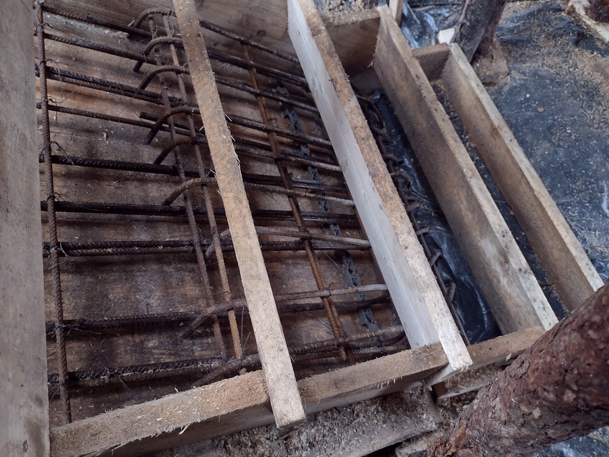 Siatka zbrojeniowa w drewnianym szalunku, widok z góry, przygotowanie do wylewki betonowej.