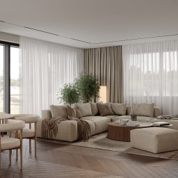 Sublime Studio Anna Pawelec - Beżowe wnętrze salonu w Warszawie: narożna sofa, okrągły stolik kawowy, drewniana podłoga w jodełkę, duże okna z zasłonami i rośliny doniczkowe.