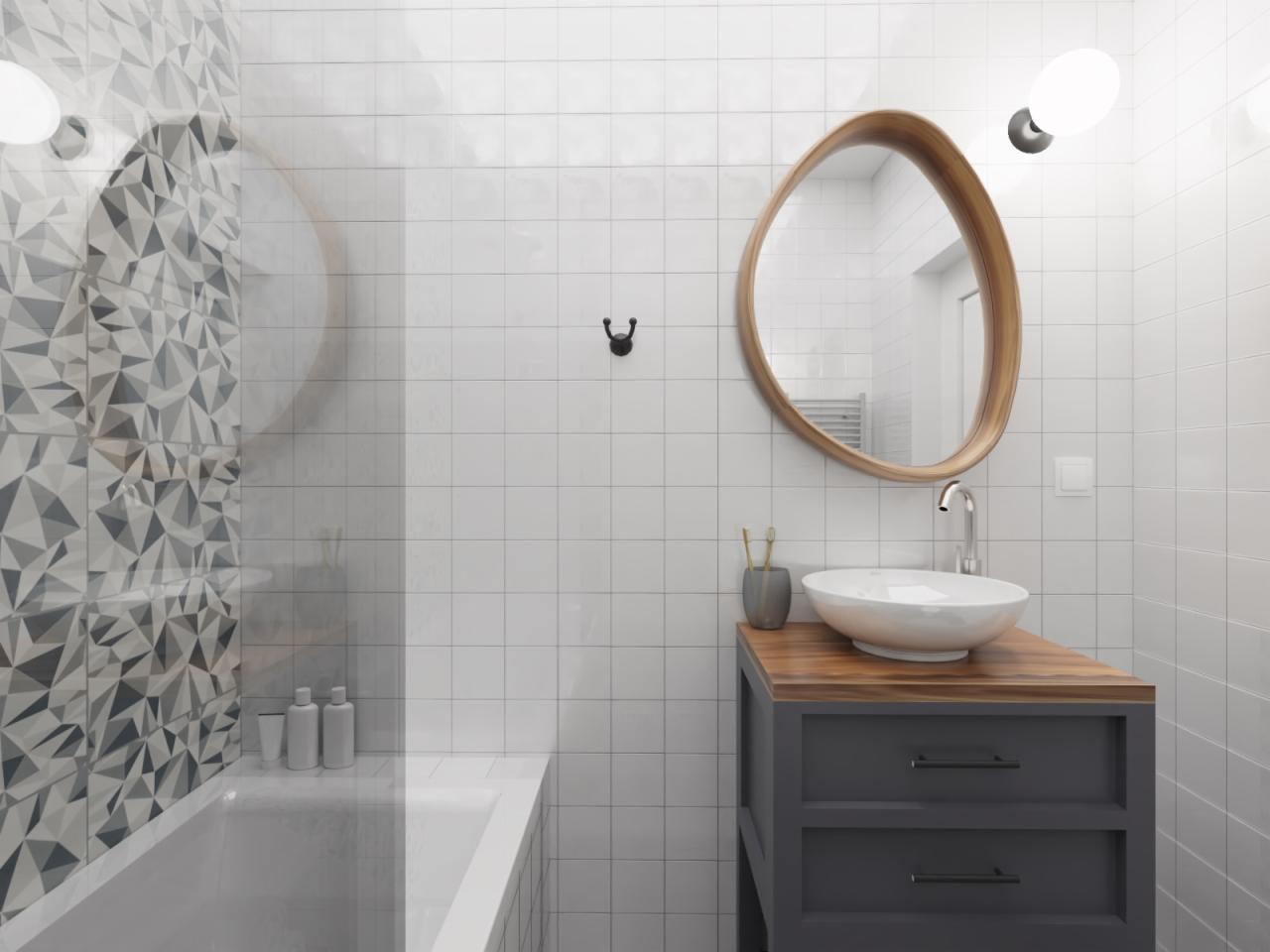 Minimalistyczna łazienka z geometryczną mozaiką, owalnym lustrem w drewnianej ramie, białą umywalką nablatową na szarej szafce z drewnianym blatem oraz białymi płytkami.