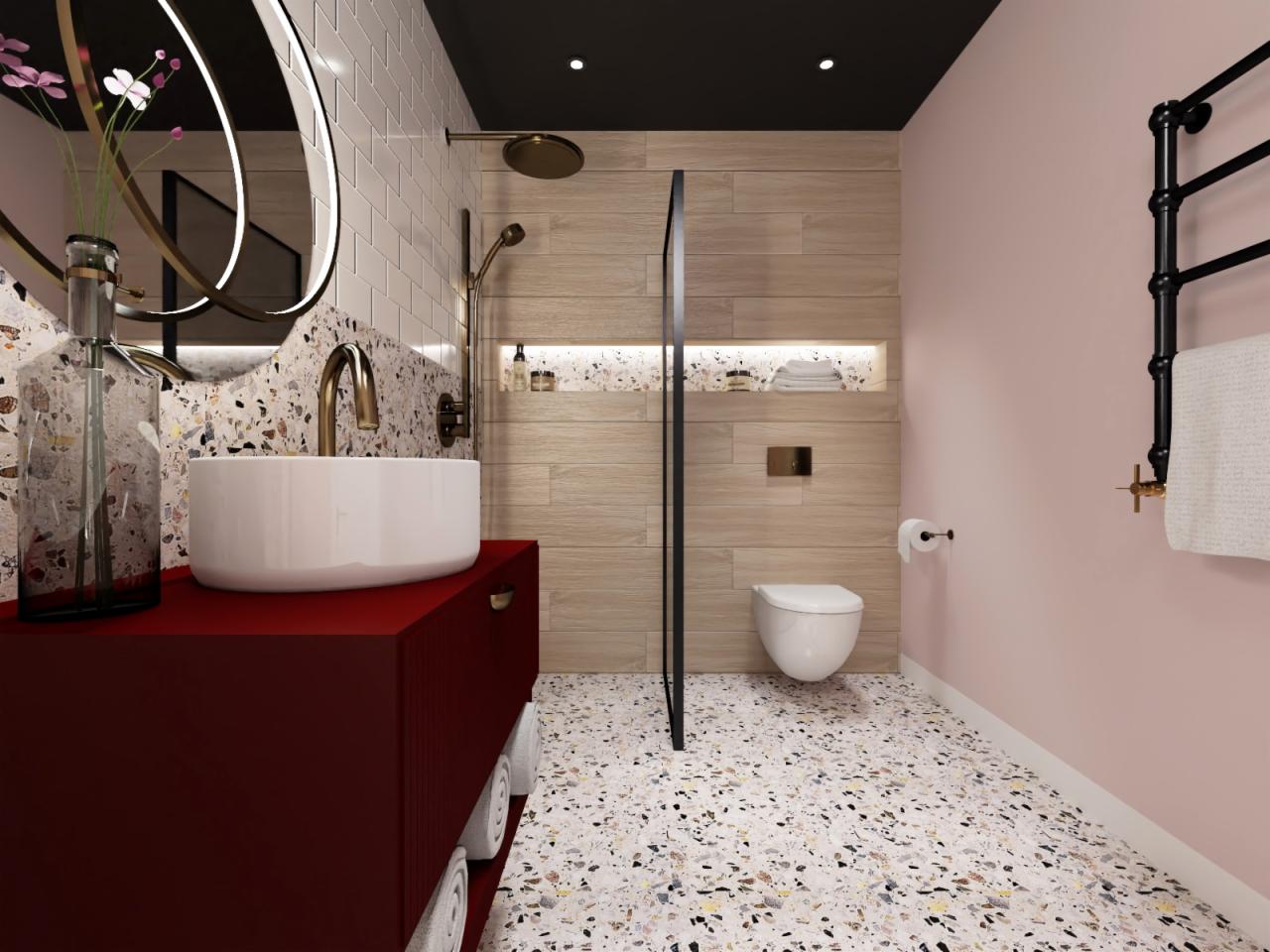 Nowoczesna łazienka z umywalką nablatową na czerwonej szafce, złotą armaturą, podłogą lastryko i drewnopodobnymi płytkami ściennymi w strefie prysznica.