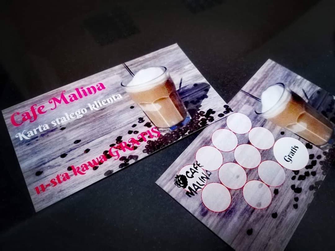 Dwie karty lojalnościowe kawiarni Cafe Malina z grafiką kawy latte i ziaren kawy, jedna z napisem '11-sta kawa GRATIS', druga z miejscami na pieczątki i napisem 'Gratis'.